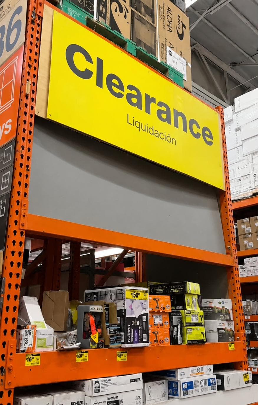 Home Depot clearance endcap with a Clearance / Liquidación sign above shelves of discounted items
