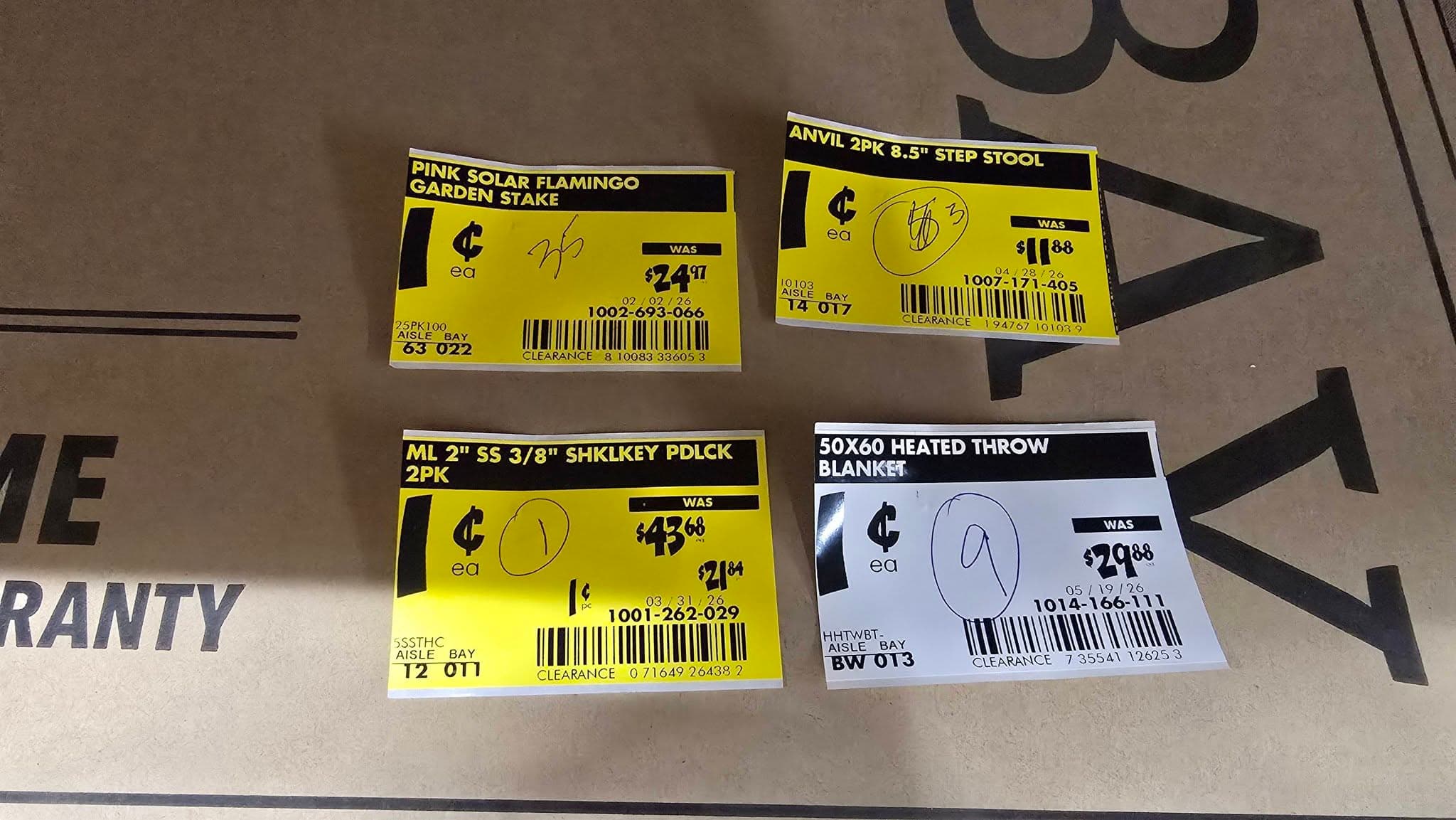 Three yellow penny clearance tags and one white one laid side by side, all marked $0.01