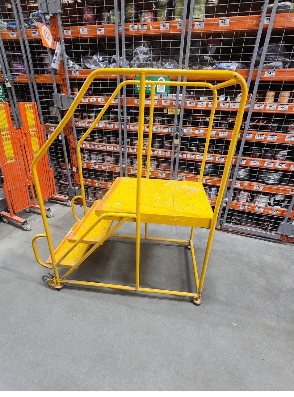 Yellow rolling customer ladder in a Home Depot aisle